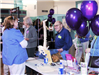 People attend event with purple balloons.