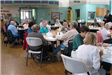 People sit at tables at a Center for Older Adults event.