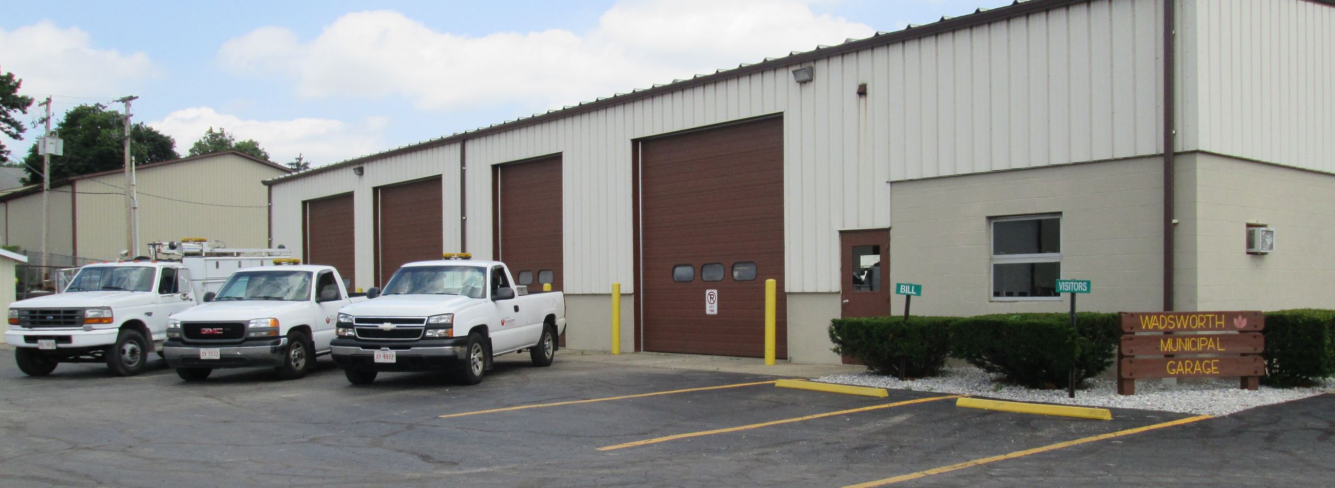 A large garage building with white trucks parked in front.