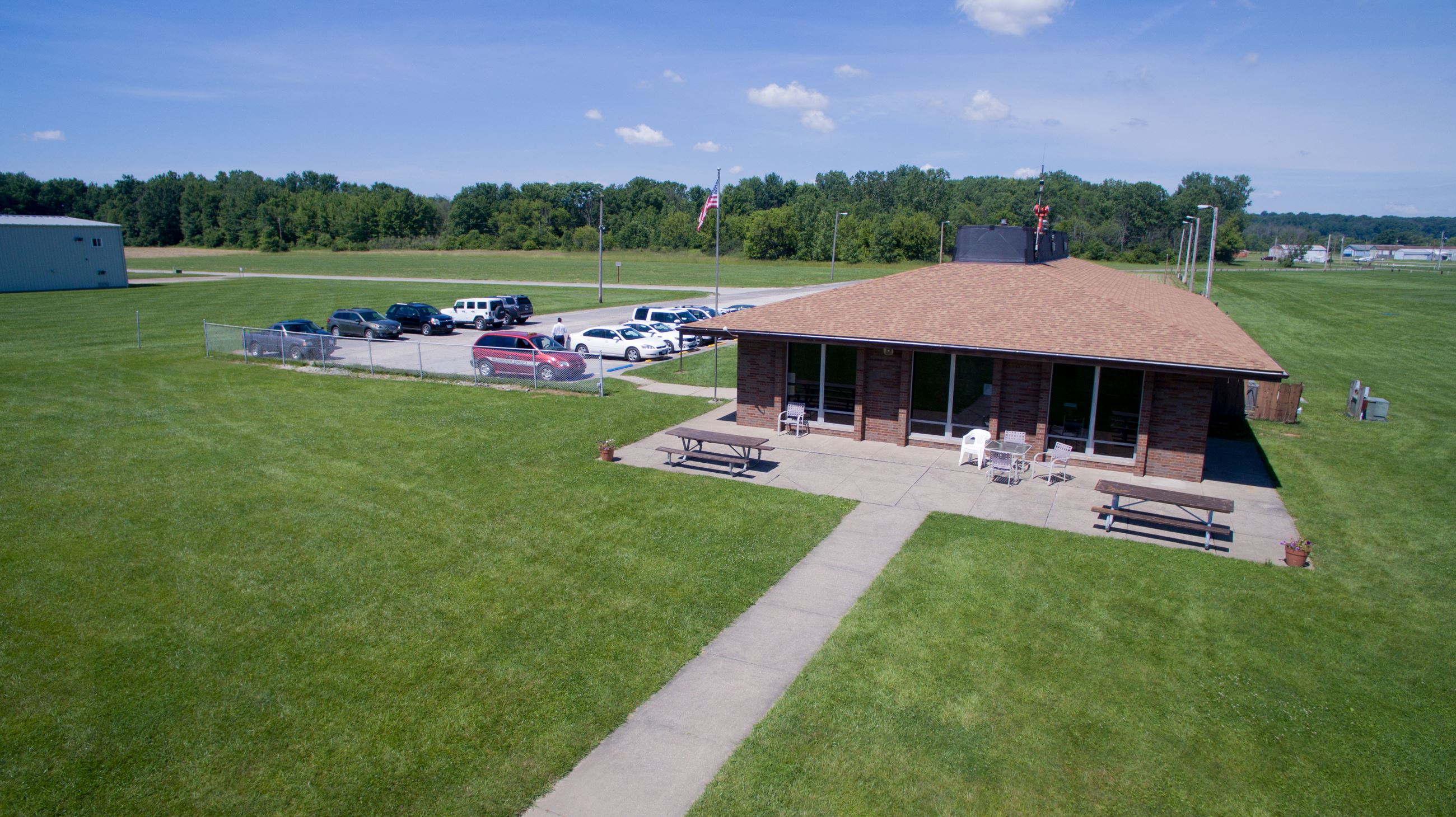 brown building surrounded by grass and a parking lot