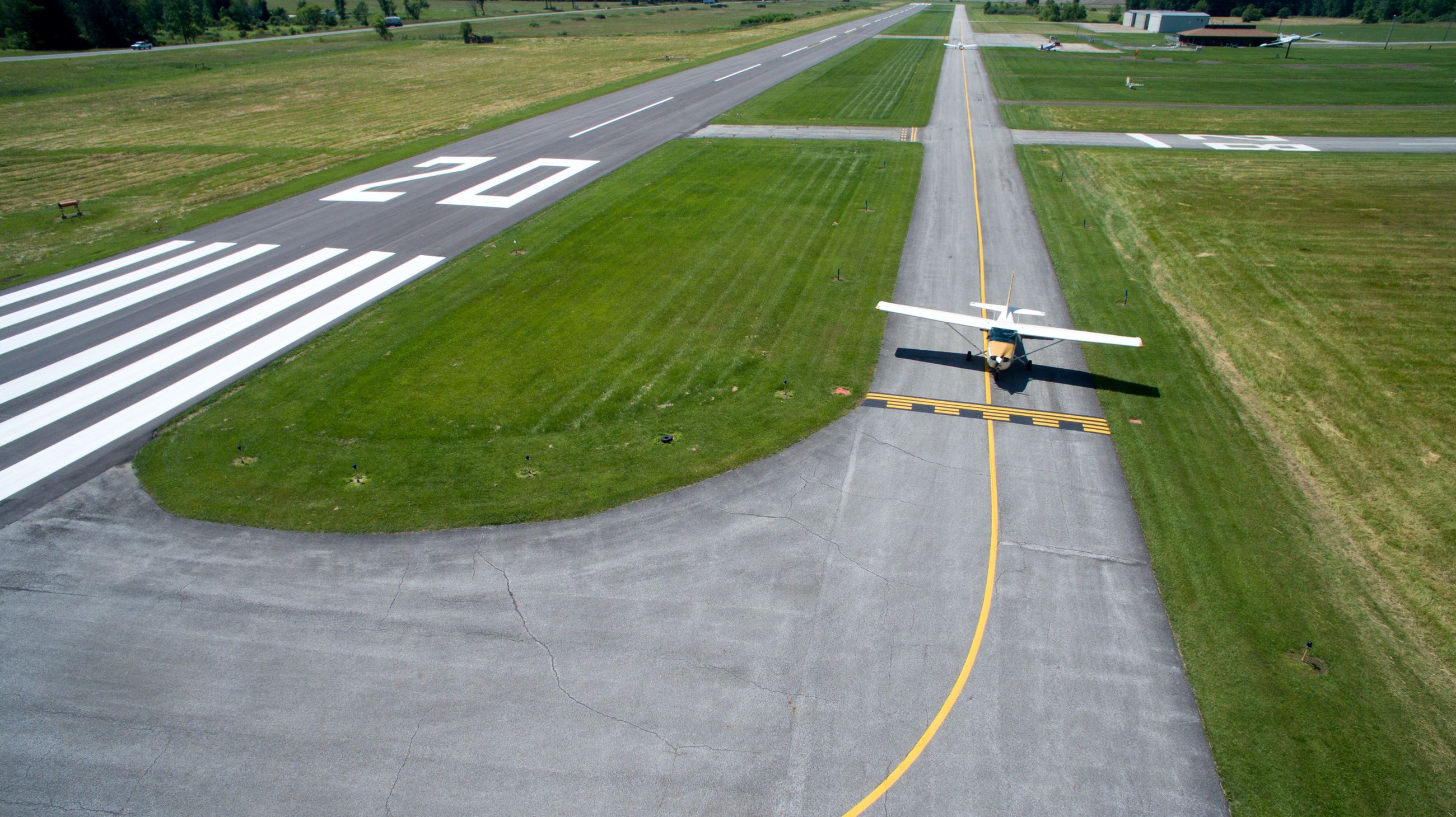 Yellow and white airplane in lane
