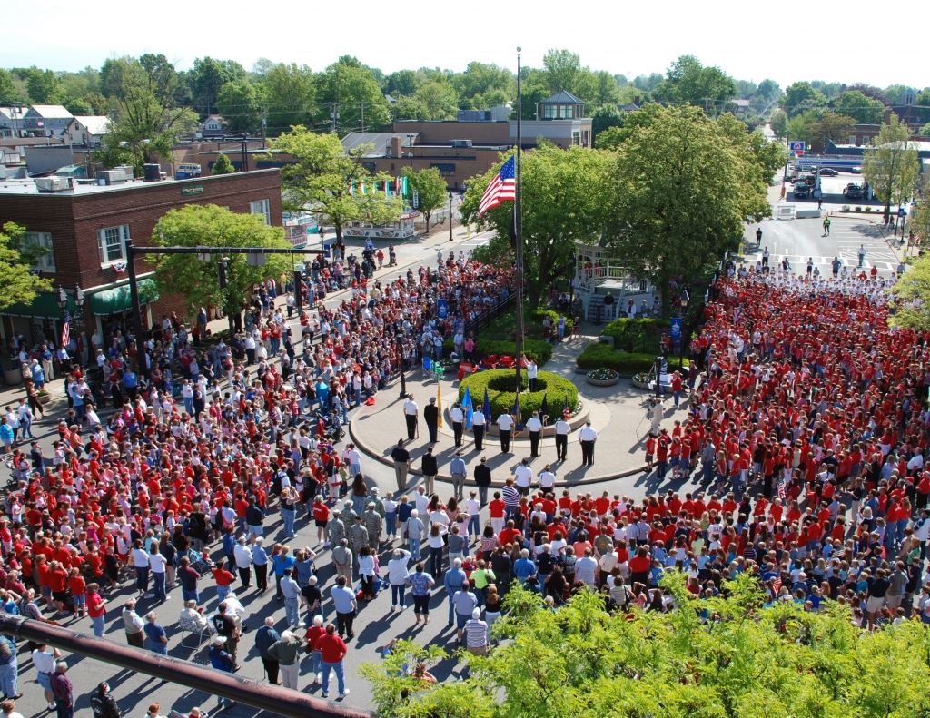 Crowd Stands Around Flag