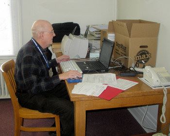 Man works on laptop at a desk.