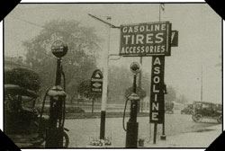 A black and white photo of a service station.